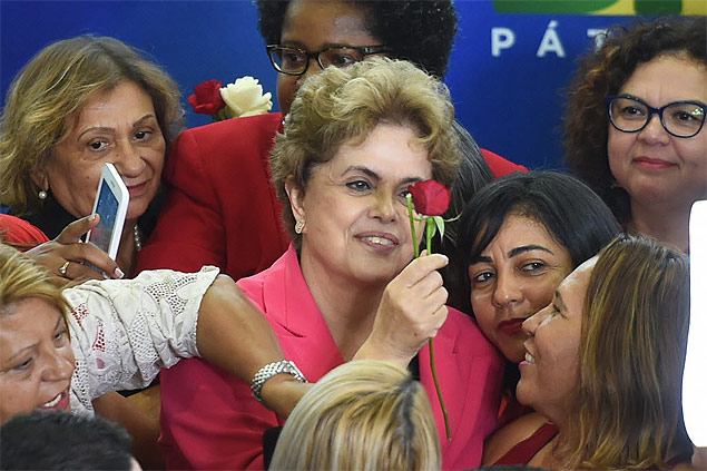 Dilma Rousseff receives a red rose during the event Women in Defense of Democracy at the Planalto Palace in Brasilia