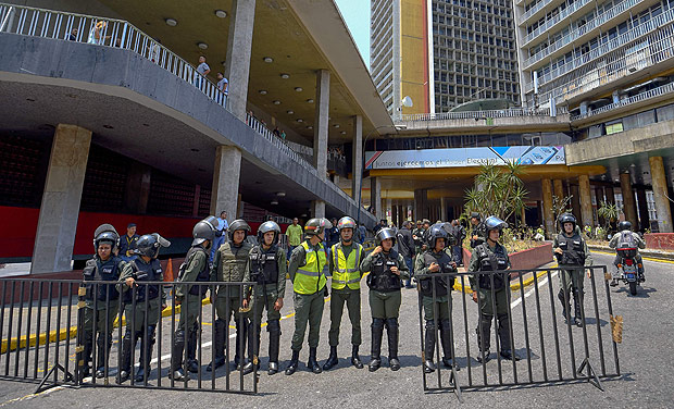Guardas nacionais da Venezuela fazem guarda na porta do Conselho Nacional Eleitoral nesta tera