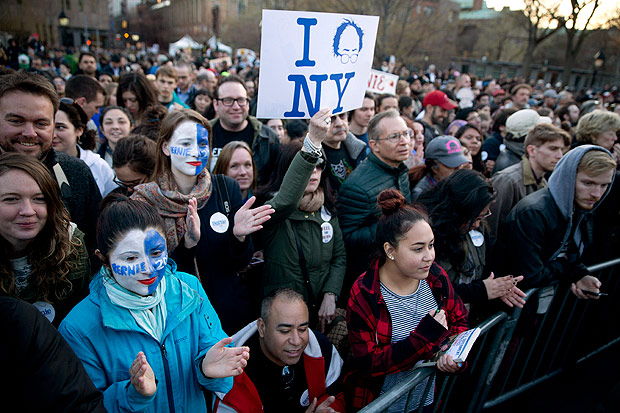 Manifestantes pintam o rosto de azul e branco antes de comcio de Bernie Sanders em Nova York