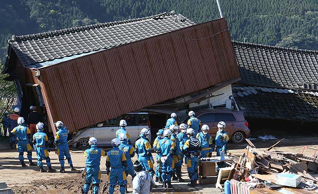 Equipe de resgate busca pessoas presas em destroos de desabamento em Mimami-Aso