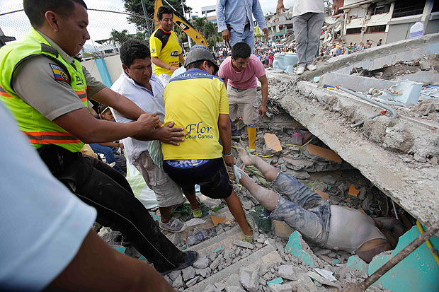 Voluntários retiram corpo sob os escombros de prédio em Pedernales após o terremoto no Equador