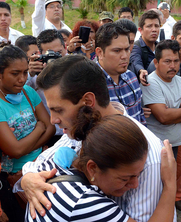 O presidente mexicano, Enrique Pea Nieto, abraa familiar de vtima em visita ao local da exploso