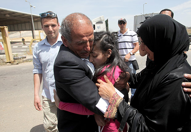 Dima Al-Wawi, 12, é abraçada pelos pais ao ser libertada, dois meses após ter sido presa por Israel