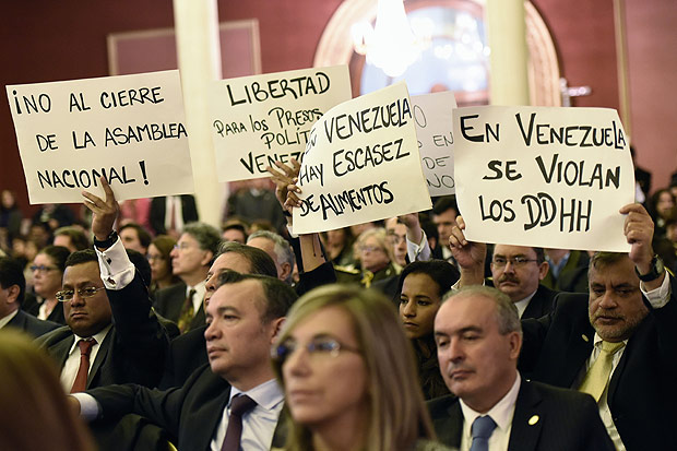 Deputados venezuelanos carregam cartazes contra Nicols Maduro no Parlamento do Mercosul