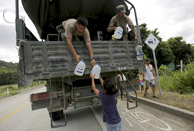 Soldados equatorianos distribuem gal�es de �gua para uma menina em Canoa, no litoral do Equador