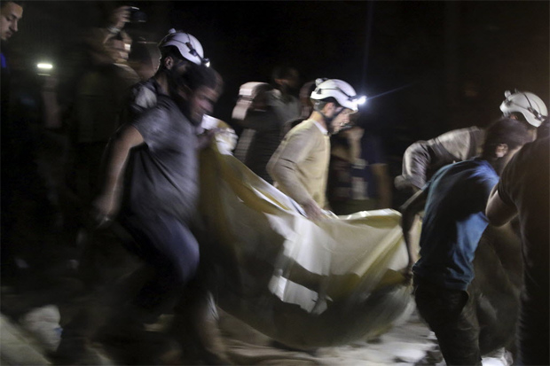 Membros da defesa civil socorrem vtimas de ataque areo contra um hospital em Aleppo