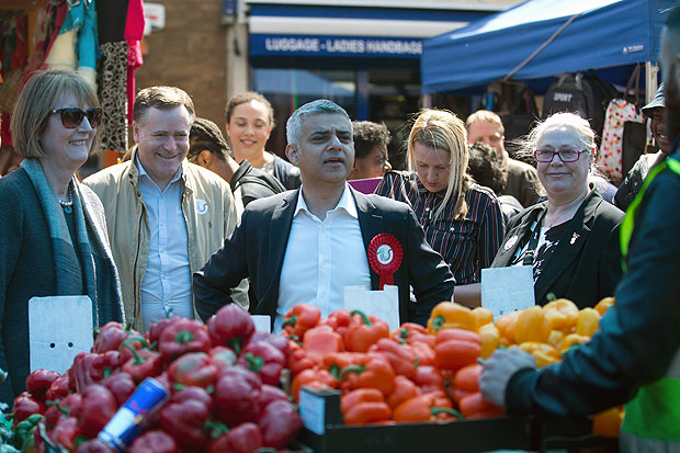 Britain's Labour party candidate for London Mayor Sadiq Khan (C) reacts as he canvasses for supporters at a market in London on May 4, 2016, on the eve of the London mayoral elections. Londoners choose their new mayor on May 5, 2016, after a straight fight between rival candidates Zac Goldsmith and Sadiq Khan dominated by negative campaigning. / AFP PHOTO / JUSTIN TALLIS