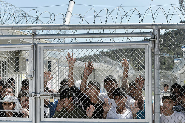 Crianças e adolescentes refugiados esperam em um centro de detenção na ilha de Lesbos, na Grécia