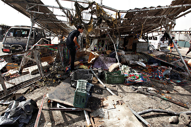 Destruição deixada por explosão causada por terroristas em mercado de Bagdá