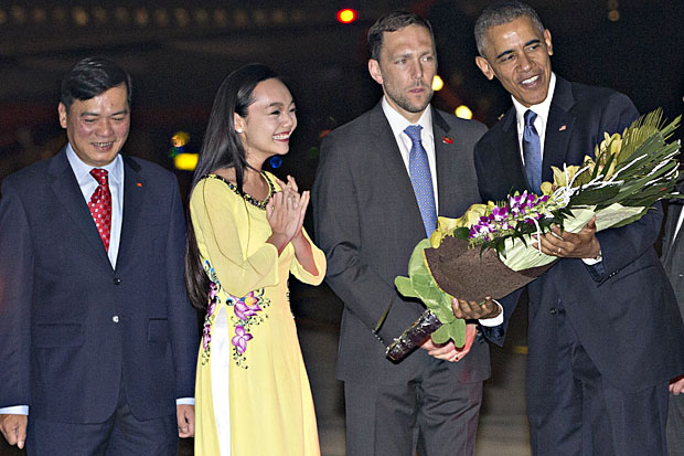 U.S. President Barack Obama is given flowers by Linh Tran, the ceremonial flower girl, as he arrives on Air Force One at Noi Bai International Airport in Hanoi, Vietnam, Sunday, May 22, 2016. The president is on a weeklong trip to Asia as part of his effort to pay more attention to the region and boost economic and security cooperation. (AP Photo/Carolyn Kaster) ORG XMIT: VNMK102