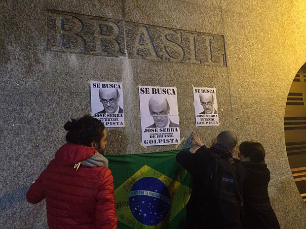 Manifestantes colam cartaz em protesto  visita do novo chanceler brasileiro, Jos Serra,  Argentina