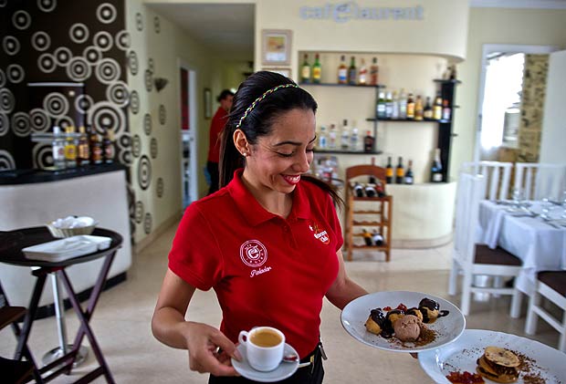 Garonete serve clientes em caf de um autnomo em Havana; Cuba libera empresas privadas