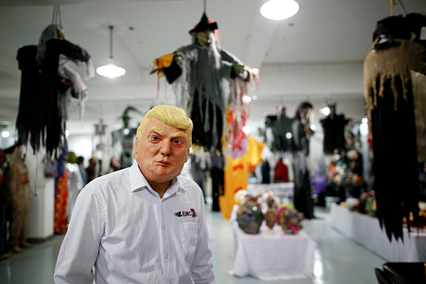 The manager of Jinhua Partytime Latex Art and Crafts Factory wearing a mask of U.S. Republican presidential candidate Donald Trump poses as he presents products to reporters at his factory's showroom in Jinhua, Zhejiang Province, China, May 25, 2016. There's no masking the facts. One Chinese factory is expecting Donald Trump to beat his likely U.S. presidential rival Hilary Clinton in the popularity stakes. At the Jinhua Partytime Latex Art and Crafts Factory, a Halloween and party supply business that produces thousands of rubber and plastic masks of everyone from Osama Bin Laden to Spiderman, masks of Donald Trump and Democratic frontrunner Hillary Clinton faces are being churned out. Sales of the two expected presidential candidates are at about half a million each but the factory management believes Trump will eventually run out the winner. 