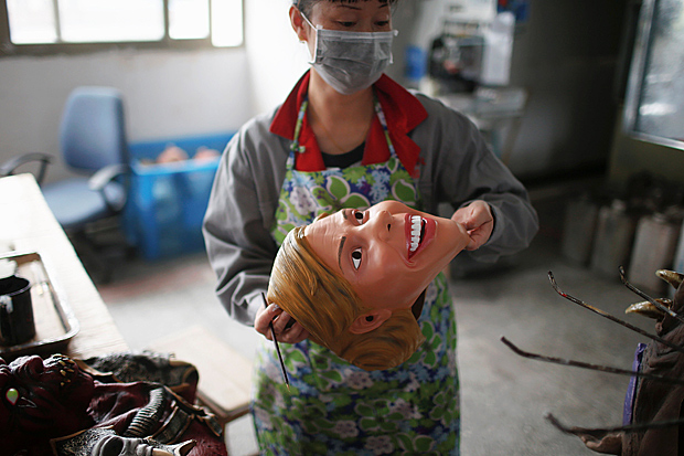 A worker checks a mask of U.S. Democratic presidential candidate Hillary Clinton, which she just painted, at Jinhua Partytime Latex Art and Crafts Factory in Jinhua, Zhejiang Province, China, May 25, 2016. There's no masking the facts. One Chinese factory is expecting Donald Trump to beat his likely U.S. presidential rival Hilary Clinton in the popularity stakes. At the Jinhua Partytime Latex Art and Crafts Factory, a Halloween and party supply business that produces thousands of rubber and plastic masks of everyone from Osama Bin Laden to Spiderman, masks of Donald Trump and Democratic frontrunner Hillary Clinton faces are being churned out. Sales of the two expected presidential candidates are at about half a million each but the factory management believes Trump will eventually run out the winner. "Even though the sales are more or less the same, I think in 2016 this mask will completely sell out," said factory manager Jacky Chen, indicating a Trump mask. REUTERS/Aly Song SEARCH "JINHUA MASK" FOR THIS STORY. SEARCH "THE WIDER IMAGE" FOR ALL STORIES. ORG XMIT: 