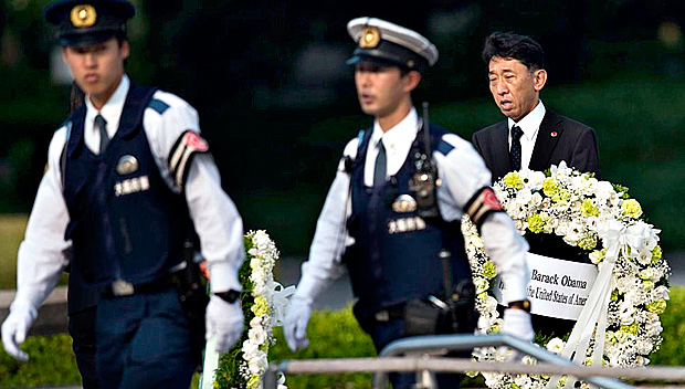 Um homem conduz a coroa de flores que o presidente dos EUA, Barack Obama, levar ao memorial da paz da cidade japonesa; visita ser a primeira de um presidente americano em exerccio ao local 