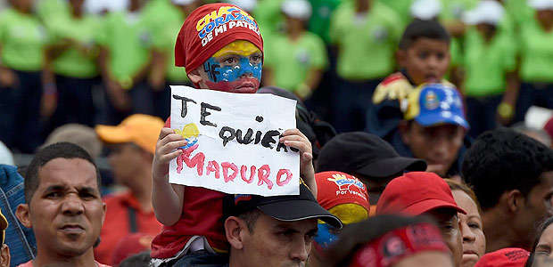 A boy holds a sign reading "I love you Maduro" -referring to Venezuelan President Nicolas Maduro- during rally in Caracas on May 14, 2016. Venezuela braced for protests Saturday after Maduro declared a state of emergency to combat the "foreign aggression" he blamed for an economic crisis that has pushed the country to the brink of collapse. / AFP PHOTO / JUAN BARRETO