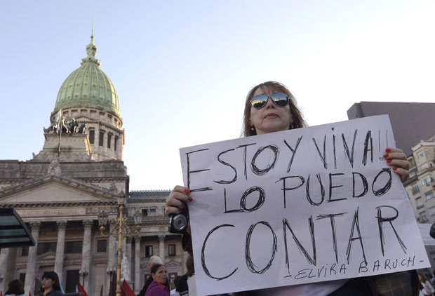 Mulher carrega cartaz dizendo "Estou viva, posso contar sobre isso" em ato contra feminicdio em 2015