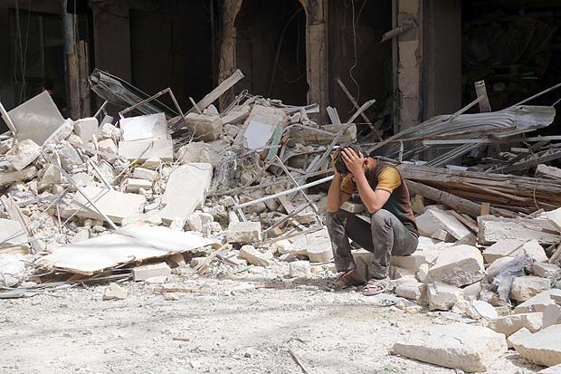 Morador da cidade de Aleppo, na Sria, avalia destruio deixada por bombardeio