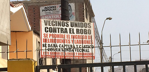 Placa na periferia de Lima mostra cerca em rua e mobilizao de vizinhos contra roubos