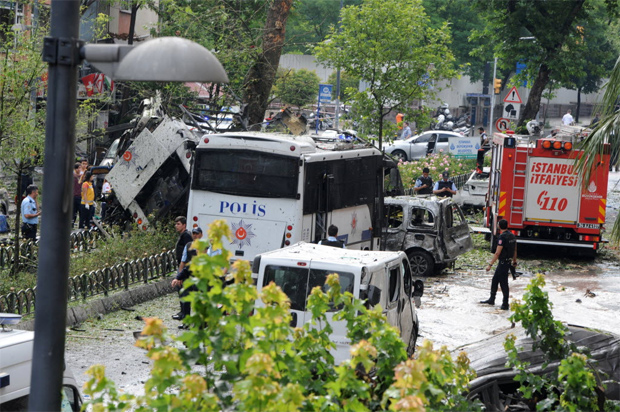 TOPSHOT - Police officers and rescuers inspect the site of a bomb attack that targeted a police bus in the Vezneciler district of Istanbul on June 7, 2016. A bomb attack targeted Turkish police in a central Istanbul district on June 7, 2016, leaving several people wounded, the state-run TRT television reported. / AFP PHOTO / DOGAN NEWS AGENCY / STRINGER / Turkey OUT