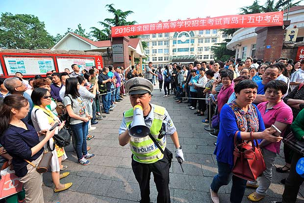 A policeman clears a path for students outside a university entrance exam in Qingdao, in China's Shandong province on June 7, 2016. Millions of children across China began sitting the annual two-day 