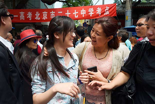 A student is greeted by parents outside a school after sitting a university entrance exam in Beijing on June 7, 2016. Millions of children across China began sitting the annual two-day "gaokao" university entrance exams on June 7. The exams are a national obsession which decides the fates of millions. / AFP PHOTO / GREG BAKER ORG XMIT: GB6050