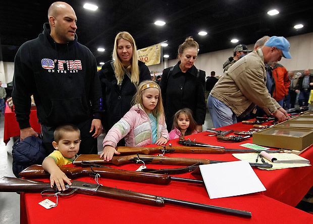 Famlia avalia armas durante o Rocky Mountain Gun Show, evento realizado em Utah em 2012