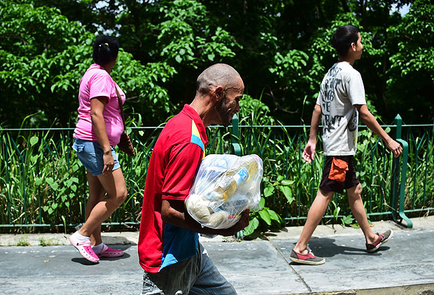 A man carries a bag of basic foodstuffs outside one of the food distribution centers called CLAP (Local Committees for Supply and Production), which are headed by community leaders, in the poor neighbourhood of 23 de Enero, in Caracas, on June 4, 2016. Shortages of basic goods have fueled looting, violent crime and vigilante justice. At least 94 looting sprees broke out in the first four months of the year, according to the Venezuelan Observatory for Social Conflict. Venezuela, home to the world's largest oil reserves, has been hit hard by the collapse in global crude prices over the past two years. The economy is forecast to contract eight percent this year, with inflation of 700 percent. / AFP PHOTO / RONALDO SCHEMIDT ORG XMIT: RSA358