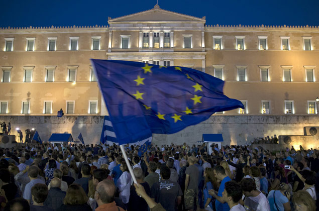 A protester waves a European Union flag in front of the parliament building during a rally calling on the government to clinch a deal with its international creditors and secure Greece's future in the Eurozone, in Athens, Greece, June 22, 2015. Euro zone finance ministers welcomed new Greek proposals for a cash-for-reform deal on Monday but said they required detailed study and it would take several days to determine whether they can lead to an agreement to avert a default. REUTERS/Marko Djurica ORG XMIT: MDJ201