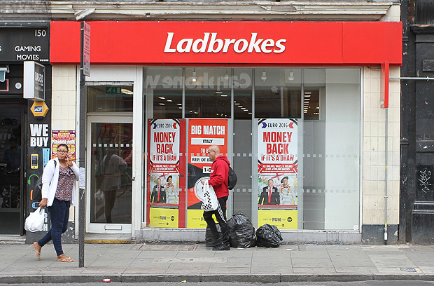 People walk past a Ladbrokes betting shop in London, Wednesday June 22, 2016. Thursday&#146;s referendum on whether to leave the European Union, which could have lasting consequences for the country and Europe, is due to break the record as the most bet-upon political event in Britain&#146;s history. (AP Photo/Leonora Beck) ORG XMIT: TH116