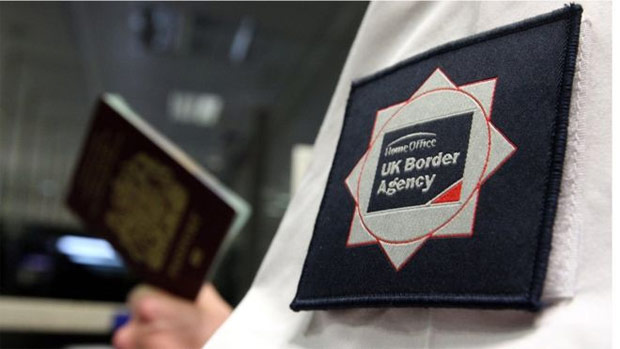 Funcionrio da imigrao britnica confere passaporte no controle de fronteiras do pas