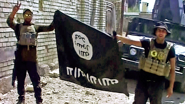 This image made from Associated Press video shows, Iraqi troops turn the Islamic State flag upside down in Fallujah, Iraq, Sunday, June 26, 2016. A senior Iraqi commander declared that the city of Fallujah was "fully liberated" from Islamic State group militants on Sunday, after a more than monthlong military operation. (AP Video via AP) ORG XMIT: CAINM110