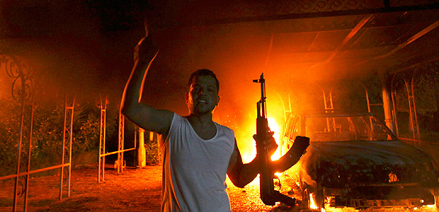 A protester reacts as the U.S. Consulate in Benghazi is seen in flames during a protest by an armed group said to have been protesting a film being produced in the United States September 11, 2012. REUTERS/Esam Al-Fetori/File Photo ORG XMIT: TOR910