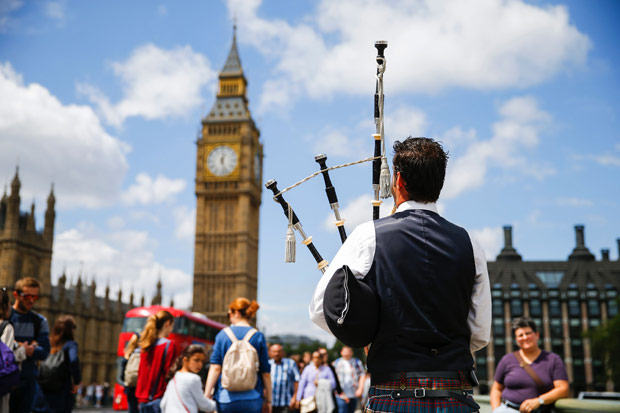 Homem com gaita de fole, tradicional instrumento escocs, toca em frente ao Big Ben, em Londres