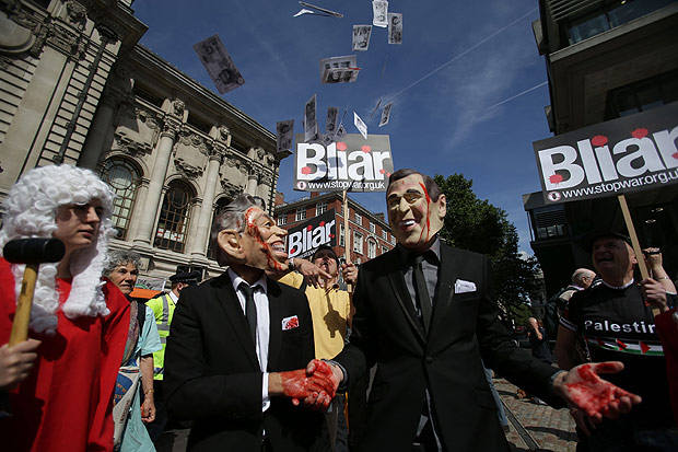 Manifestantes usam mscaras do ex-premi britnico Tony Blair (esq.) e de George W. Bush em Londres