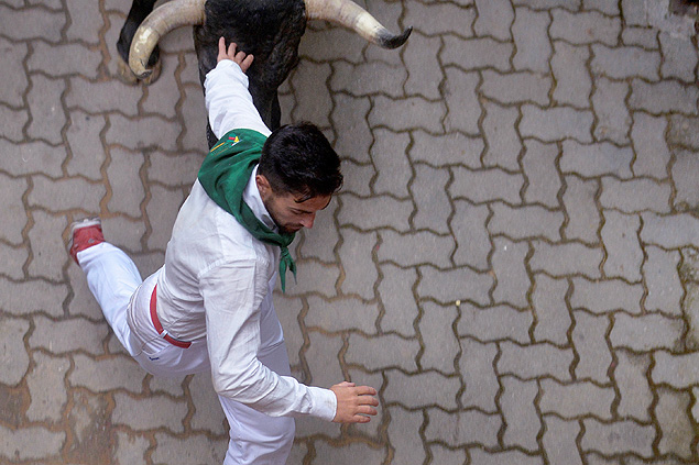 A runner sprints in front of a Jose Escolar Gil fighting bull near the entrance to the bullring during the third running of the bulls at the San Fermin festival in Pamplona, northern Spain, July 9, 2016. REUTERS/Vincent West ORG XMIT: VPW14