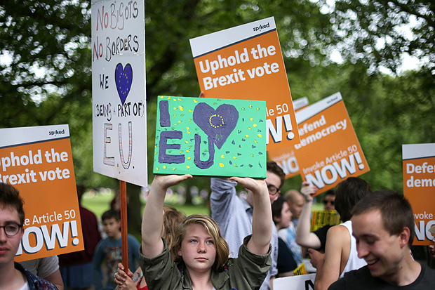 Pro-European Union supporters and pro-Brexit supporters hold up placards during a demonstration against Brexit in Green Park in London on July 9, 2016. The British government on Saturday formally rejected a petition signed by more than 4.125 million people calling for a second referendum on Britain's membership of the EU. / AFP PHOTO / Daniel Leal-Olivas