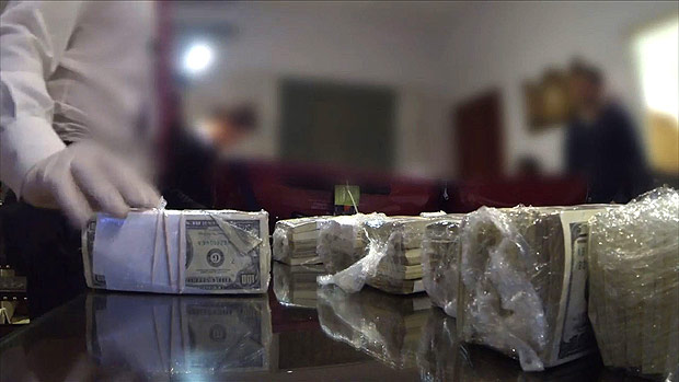Screen grab from a handout video released on June 15, 2016 by the Argentinian police showing money, weapons, jewels and other objects seized to former minister Jose Lopez, 55, caught when he was trying to hide it at a nunnery. / AFP PHOTO / Argentine Police / HO / RESTRICTED TO EDITORIAL USE - MANDATORY CREDIT 