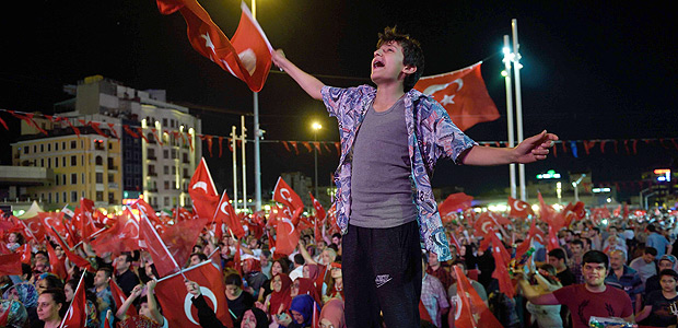 A young man waves a Turkish flag as people gather for a meeting in support of the Turkish president on Taksim Square in Istanbul on July 19, 2016. Turkey widened its massive post-coup purge to schools and the media on July 19, vowing to root out supporters of an exiled Islamic cleric it accuses of orchestrating the attempted power grab. / AFP PHOTO / DANIEL MIHAILESCU ORG XMIT: DAN2093