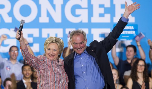 (FILES) This file photo taken on July 14, 2016 shows US Democratic Presidential candidate Hillary Clinton and US Senator Tim Kaine, Democrat of Virginia, waving during a campaign rally at Ernst Community Cultural Center in Annandale, Virginia. Clinton is expected to reveal her vice presidential pick by July 23, when she campaigns in Florida. Kaine is mentioned first in virtually ever veepstakes discussion because he ticks so many boxes: strong foreign policy experience (he is on the armed services and foreign relations committees); loyal lawmaker from a battleground state; Spanish-speaker. / AFP PHOTO / SAUL LOEB ORG XMIT: SAL003