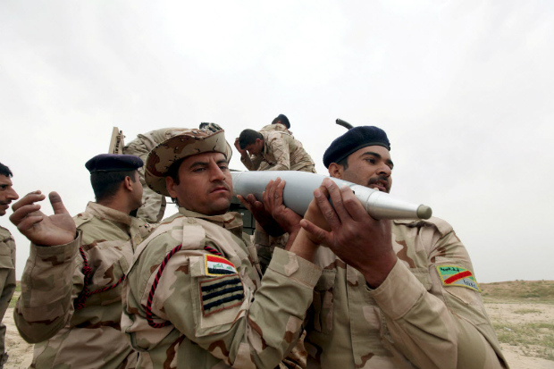 Soldados iraquianos carregam arma durante confronto com o Estado Islmico perto de Mosul, no Iraque