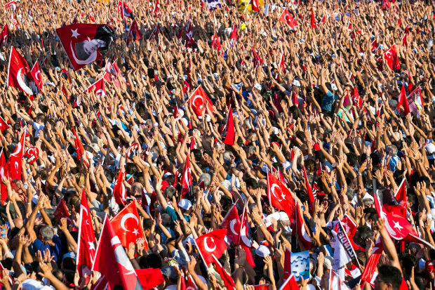 Manifestantes agitam os braos e bandeiras na praa Taksim, em Istambul, em ato pr-democracia