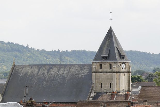 This photo taken on July 26, 2016 shows a partial view of the Saint-Etienne church in the Normandy city of Saint-Etienne-du-Rouvray where a priest was killed today in the latest of a string of attacks against Western targets claimed by or blamed on the Islamic State jihadist group. French President said that two men who attacked a church and slit the throat of a priest had "claimed to be from Daesh", using the Arabic name for the Islamic State group. Police said they killed two hostage-takers in the attack in the Normandy town of Saint-Etienne-du-Rouvray, 125 kilometres (77 miles) north of Paris. / AFP PHOTO / MATTHIEU ALEXANDRE