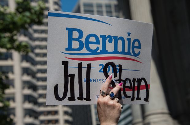 A supporter of former US Democratic presidential candidate Bernie Sanders and of Green Party candidate Jill Stein holds a sign at a rally at City Hall in Philadelphia on July 25, 2016, as Democrats gather to formally annoint Hillary Clinton as their candidate for the November presidential election at the Democratic National Convention. / AFP PHOTO / NICHOLAS KAMM ORG XMIT: NK373
