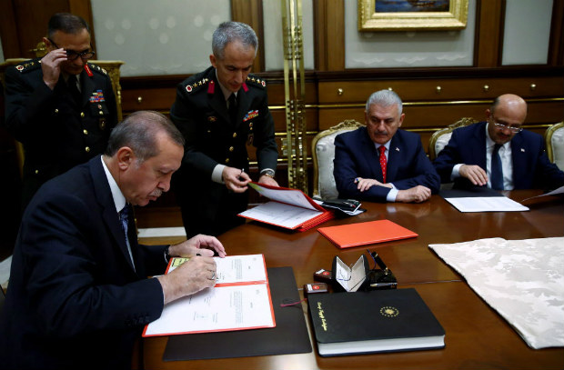 O presidente Recep Tayyip Erdogan assina documento em reunio do Conselho Militar Supremo