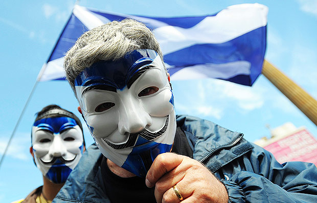 TOPSHOT - Pro-Scottish Independence supporters with Scottish Saltire flag masks pose for a picture at a rally in George Square in Glasgow, Scotland on July 30, 2016 to call for Scottish independence from the UK. Several thousand pro-independence supporters marched and rallied in central Glasgow calling for Sottish independence from the UK. Independence for Scotland was rejected in a 2014 referendum but the June 2016 EU referendum result in favour of Brexit has ignited a new call for independence. / AFP PHOTO / Andy Buchanan
