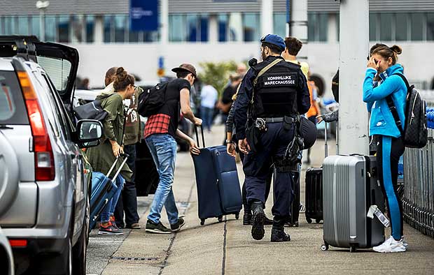***NETHERLANDS OUT*** Netherland's military police carry out additional patrols as passengers arrive to Schiphol Airport in Amsterdam on July 30, 2016. Security was stepped up in and around Amsterdam's Schiphol airport on July 30 following a threat, local authorities said in a statement, adding that aviation was unaffected. / AFP PHOTO / ANP / Remko de Waal / Netherlands OUT ORG XMIT: 46796118