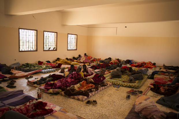 Imigrantes ilegais descansam em uma das salas do centro de deteno de Karareem, na Lbia