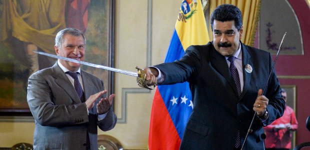 Venezuelan President Nicolas Maduro (R) holds a sword, given as gift by Russian oil company Rosneft's CEO, Igor Sechin, during the signing of agreements at Miraflores presidential Palace in Caracas on July 28, 2016. / AFP PHOTO / FEDERICO PARRA ORG XMIT: FPZ509