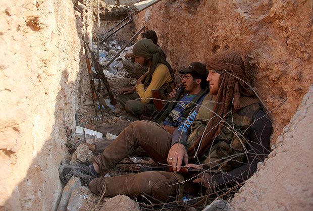 Fighters from the former Al-Nusra Front -- renamed Fateh al-Sham Front after breaking from Al-Qaeda -- sit in a trench after they seized key positions south of Aleppo in a major offensive to break the government siege of the city, on August 6, 2016, the Syrian Observatory for Human Rights said. Fateh al-Sham Front announced having captured two military academies and a third military position south of Aleppo. / AFP PHOTO / Omar haj kadour